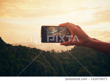 Sunset, nature and hand with phone for picture on vacation, adventure or weekend trip in Brazil. Evening, mobile and person with cellphone for photography of outdoor dawn sky on holiday for travel. Sunset, nature and hand with phone for picture on vacation, adventure or weekend trip in Brazil. Evening, mobile and person with cellphone for photography of outdoor dawn sky on holiday for travel. 142678071