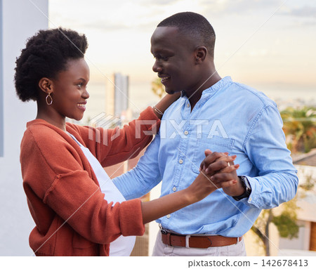 Couple, happy and dancing on balcony outside for bonding, romance and intimate moment. Smile, African people and holding hands for trust, love and support in pregnancy for marriage and celebration Couple, happy and dancing on balcony outside for bonding, romance and intimate moment. Smile, African people and holding hands for trust, love and support in pregnancy for marriage and celebration 142678413