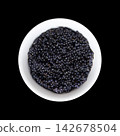 Black caviar made from lumpfish roe, in a white bowl from above over black. Affordable, small, deep black dyed, salted fish eggs from Cyclopterus lumpus, also called lumpsucker, used as garnish. Photo Black caviar made from lumpfish roe, in a white bowl from above over black. Affordable, small, deep black dyed, salted fish eggs from Cyclopterus lumpus, also called lumpsucker, used as garnish. Photo 142678504