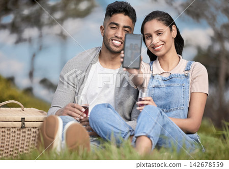 Couple, smartphone and selfie at picnic in park for anniversary, romance and love in Peru. Happy man, woman and together with phone in field for picture, wine and celebration in relationship Couple, smartphone and selfie at picnic in park for anniversary, romance and love in Peru. Happy man, woman and together with phone in field for picture, wine and celebration in relationship 142678559