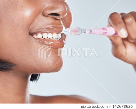 Black woman, closeup and mouth with toothbrush for dental hygiene on a white studio background. Young African, female person or model with smile in satisfaction for oral, gum care or morning routine Black woman, closeup and mouth with toothbrush for dental hygiene on a white studio background. Young African, female person or model with smile in satisfaction for oral, gum care or morning routine 142678626