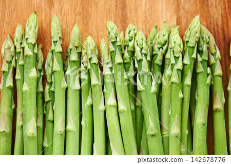 Vegetables, asparagus and food for diet, ingredients and prepare meal in kitchen with green produce on wood table. Dinner, lunch and catering with healthy cuisine, fresh and organic for vegan Vegetables, asparagus and food for diet, ingredients and prepare meal in kitchen with green produce on wood table. Dinner, lunch and catering with healthy cuisine, fresh and organic for vegan 142678776