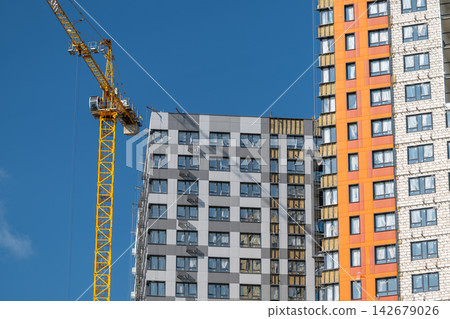 Urban construction site showcasing modern apartment buildings under vibrant blue skies Urban construction site showcasing modern apartment buildings under vibrant blue skies 142679026