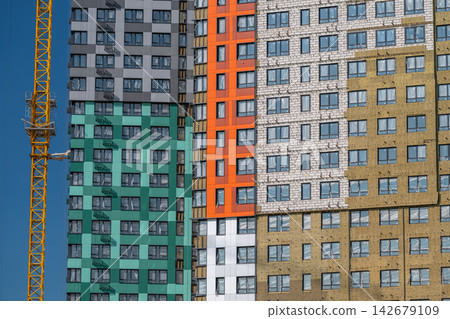 Vibrant urban skyline featuring newly constructed buildings with diverse architectural styles under a clear blue sky Vibrant urban skyline featuring newly constructed buildings with diverse architectural styles under a clear blue sky 142679109