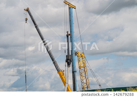 Heavy machinery at work building strong foundations under a cloudy sky Heavy machinery at work building strong foundations under a cloudy sky 142679288