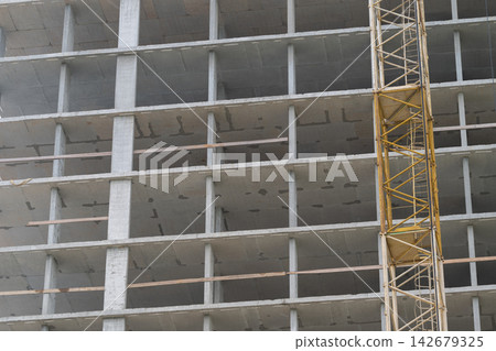 Construction site revealing skeletal structure of a high-rise building during daylight Construction site revealing skeletal structure of a high-rise building during daylight 142679325