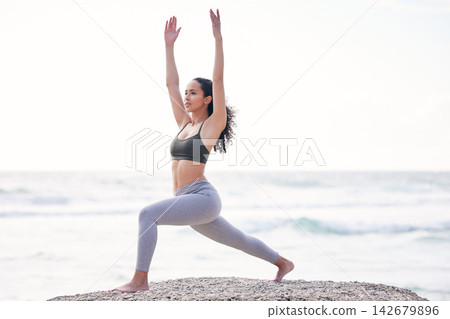 Yoga, warrior pose and woman on beach with balance for stretching arms, mental health and wellness. Ocean, female yogi and endurance for exercise, fitness and thinking with pilates by mockup space Yoga, warrior pose and woman on beach with balance for stretching arms, mental health and wellness. Ocean, female yogi and endurance for exercise, fitness and thinking with pilates by mockup space 142679896
