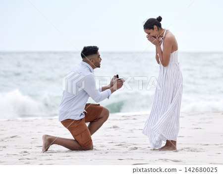 Couple, proposal and ring at beach on vacation, holiday and destination for marriage as boyfriend and girlfriend. Happy woman, man and engagement in Bali for relationship, goals and surprise on date Couple, proposal and ring at beach on vacation, holiday and destination for marriage as boyfriend and girlfriend. Happy woman, man and engagement in Bali for relationship, goals and surprise on date 142680025