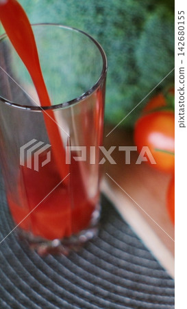 Vertical video. Woman pouring fresh tomato juice in glass on fresh vegetables background. Vertical video. Woman pouring fresh tomato juice in glass on fresh vegetables background. 142680155