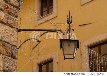 Vintage street lamp with string lights against yellow wall 142680292