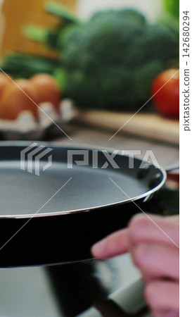 Vertical video. Woman hand turn on induction stove to cook. Finger touching sensor button on induction or electrical hob. Vertical video. Woman hand turn on induction stove to cook. Finger touching sensor button on induction or electrical hob. 142680294