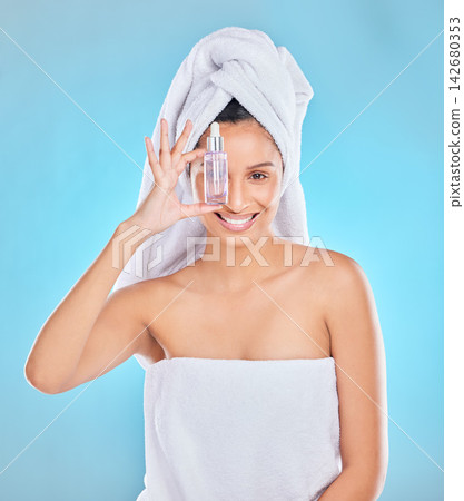 Model, skincare and portrait, woman and serum in studio on blue background for beauty. Face, product and antiaging oil with an attractive, luxury and wellness for dermatology for health or makeup Model, skincare and portrait, woman and serum in studio on blue background for beauty. Face, product and antiaging oil with an attractive, luxury and wellness for dermatology for health or makeup 142680353