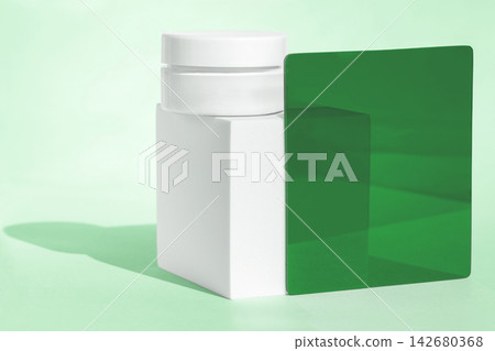 Minimal skincare cream container on block with green glass Minimal skincare cream container on block with green glass 142680368