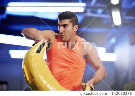 Man, sandbag or gym as fitness, strength or thinking of wellness, exercise or health as self care. Confident male bodybuilder, weight or lifting in power, cardio or performance as active commitment 142680378