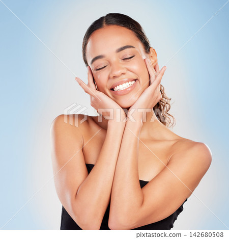 Makeup, skincare and beauty of happy woman in studio for glow, shine or health isolated on blue background. Face, touch and smile of model in cosmetics for dermatology or wellness with eyes closed Makeup, skincare and beauty of happy woman in studio for glow, shine or health isolated on blue background. Face, touch and smile of model in cosmetics for dermatology or wellness with eyes closed 142680508