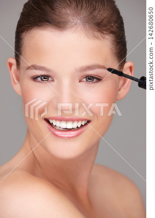 Makeup, cosmetics and portrait of woman with mascara in studio for wellness, skincare product or beauty on grey background. Smile, application and model by eyelash wand for glamour, makeover or glow 142680650