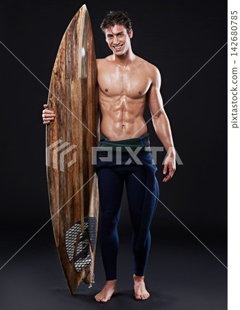 Studio, surfboard and portrait of male surfer, wetsuit and athlete isolated on black background. Body, swimsuit and water sports for man model person, equipment and wooden board for fitness or hobby 142680785