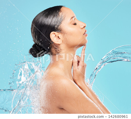 Cleaning, water splash or skincare of woman for health, hygiene or wellness isolated on blue studio background. Shower, bath or model wash in liquid for dermatology, beauty or facial with eyes closed Cleaning, water splash or skincare of woman for health, hygiene or wellness isolated on blue studio background. Shower, bath or model wash in liquid for dermatology, beauty or facial with eyes closed 142680961