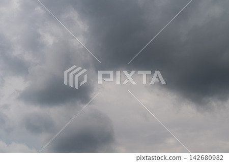 Brooding clouds gather over a serene landscape hinting at an impending storm in the late afternoon sky Brooding clouds gather over a serene landscape hinting at an impending storm in the late afternoon sky 142680982