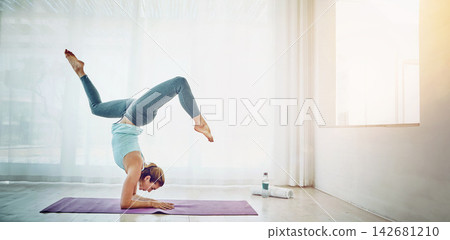 Yoga, woman and handstand on floor for exercise in home with balance, flexibility and arm strength. Pilates, yogi and fitness for strong core, wellness and healthy body with morning routine in lounge Yoga, woman and handstand on floor for exercise in home with balance, flexibility and arm strength. Pilates, yogi and fitness for strong core, wellness and healthy body with morning routine in lounge 142681210