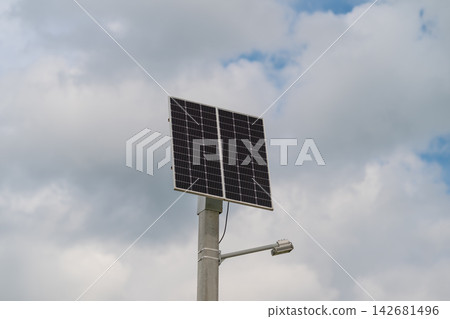 Harnessing sunlight beneath a vast sky with fluffy clouds a solar panel stands tall symbolizing renewable energy in a serene outdoor setting Harnessing sunlight beneath a vast sky with fluffy clouds a solar panel stands tall symbolizing renewable energy in a serene outdoor setting 142681496
