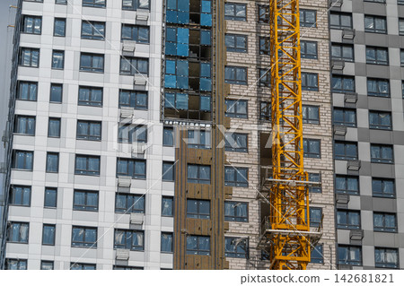 Modern construction site showcasing sleek architecture and a vibrant crane against a clear blue sky Modern construction site showcasing sleek architecture and a vibrant crane against a clear blue sky 142681821