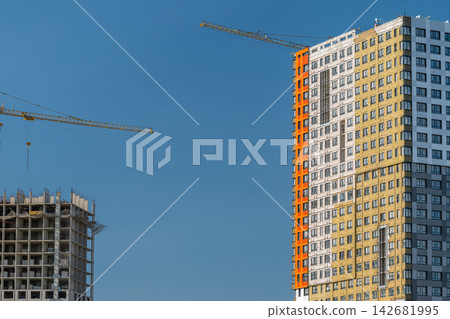 Construction of modern buildings showcasing cranes and vibrant architecture against a clear blue sky Construction of modern buildings showcasing cranes and vibrant architecture against a clear blue sky 142681995
