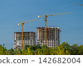Skyward towers rise amidst a blue backdrop showcasing the dynamic progress of construction in a thriving urban landscape 142682004