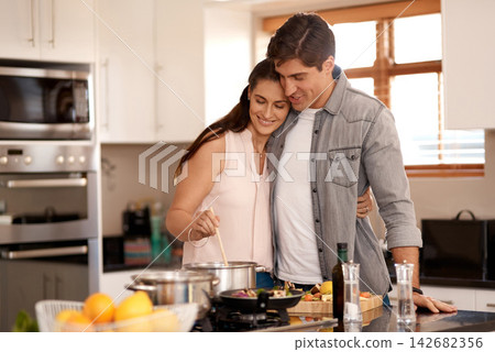 Couple, cooking and kitchen in hug, supper and romantic with bonding, relationship and nutrition. Preparation, meal and pots for healthy food, stove and happy in diet, marriage and people in home Couple, cooking and kitchen in hug, supper and romantic with bonding, relationship and nutrition. Preparation, meal and pots for healthy food, stove and happy in diet, marriage and people in home 142682356