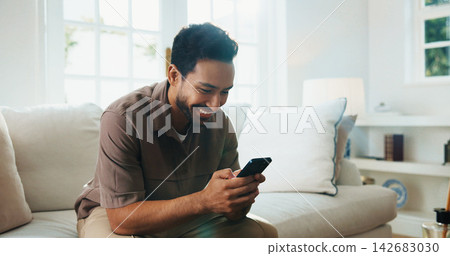 Texting, smile and man on sofa with phone, online communication and social media scroll on day off. Digital, happy and person in home with tech, message notification and chatting on weekend break. Texting, smile and man on sofa with phone, online communication and social media scroll on day off. Digital, happy and person in home with tech, message notification and chatting on weekend break. 142683030