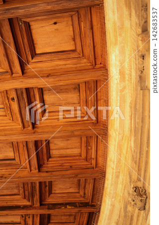 Ornate wooden ceiling and stone archway detail showing geometric patterns and intricate craftsmanship Ornate wooden ceiling and stone archway detail showing geometric patterns and intricate craftsmanship 142683537