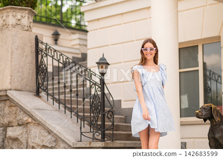 Young woman in a white dress near the nice house Young woman in a white dress near the nice house 142683599