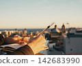 Writing on a rooftop with a cityscape view at sunset 142683990