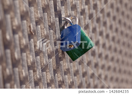 Blue and Green Padlocks Attached to Metal Grid Blue and Green Padlocks Attached to Metal Grid 142684235