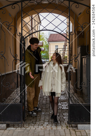 Young couple walking through an ornate iron gate Young couple walking through an ornate iron gate 142684564