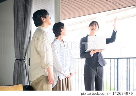 一位女房產經紀人正在向一對夫婦介紹房產資訊。 一位女房產經紀人正在向一對夫婦介紹房產資訊。 142684979