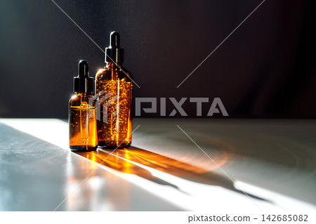 Amber dropper bottles displaying skincare serum with shadows Amber dropper bottles displaying skincare serum with shadows 142685082