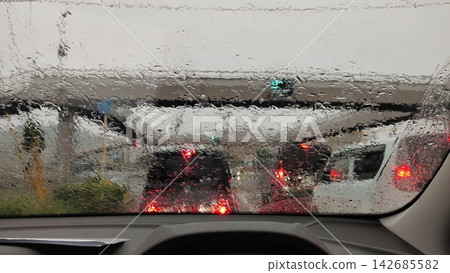 Car windshield with poor visibility due to heavy rain and water droplets (water-repellent coating - before material) Car windshield with poor visibility due to heavy rain and water droplets (water-repellent coating - before material) 142685582
