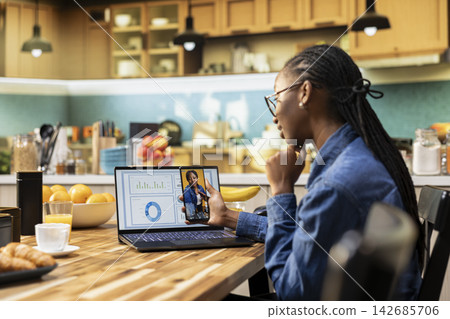 Remote worker watching social media videos on mobile app at home, working remotely and browsing short live content on smartphone. Doomscrolling engaging funny videos, leisure activity. 142685706