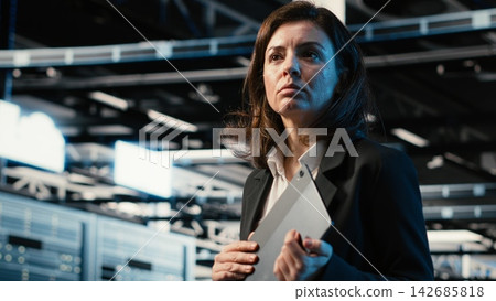 Automation, tablet and engineer walking in data center, monitoring industrial systems. IT expert Server room IT professional using device to oversee network equipment performance Automation, tablet and engineer walking in data center, monitoring industrial systems. IT expert Server room IT professional using device to oversee network equipment performance 142685818