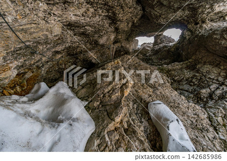 Rocky Mountain Cave with Snow and Climbing Cable Trail Rocky Mountain Cave with Snow and Climbing Cable Trail 142685986