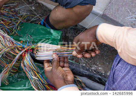 Telecom Technician Splicing Colorful Fiber Optic Cables Telecom Technician Splicing Colorful Fiber Optic Cables 142685996