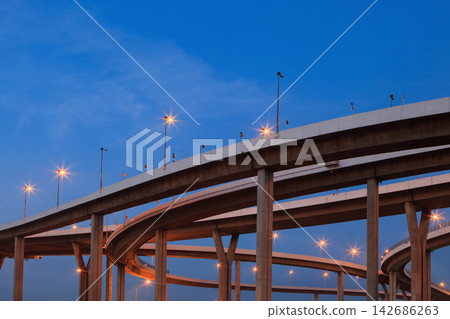 Urban Highway Interchange at Blue Hour with Glowing Streetlights Urban Highway Interchange at Blue Hour with Glowing Streetlights 142686263
