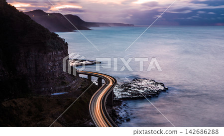 Coastal Highway Light Trails at Twilight Over Ocean Cliffs Coastal Highway Light Trails at Twilight Over Ocean Cliffs 142686288