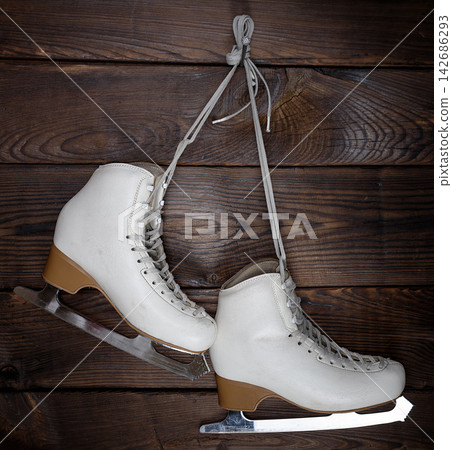 White Figure Ice Skates on Rustic Wooden Background 142686293