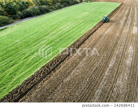 Tractor Plowing Rural Field in Aerial Farm Landscape Tractor Plowing Rural Field in Aerial Farm Landscape 142686431