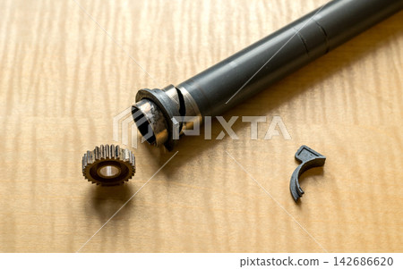 Broken Metal Tube and Mechanical Parts on Wooden Workbench 142686620