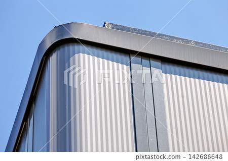 Modern Corrugated Metal Building Facade Against Blue Sky Modern Corrugated Metal Building Facade Against Blue Sky 142686648