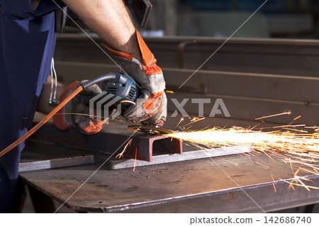 Industrial Worker Grinding Steel with Angle Grinder and Sparks Industrial Worker Grinding Steel with Angle Grinder and Sparks 142686740