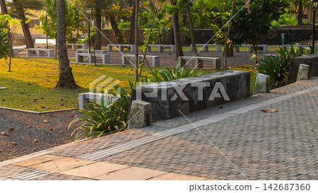 An empty park with rows of benches illuminated by golden-hour light An empty park with rows of benches illuminated by golden-hour light 142687360